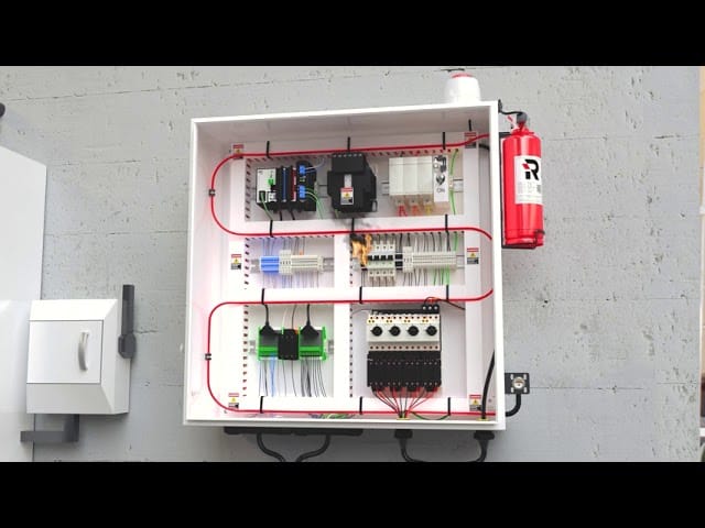 Bir elektrik panosunun içine yerleştirilmiş, silindir şeklinde bir yangın söndürme tüpü ve dedektörler.